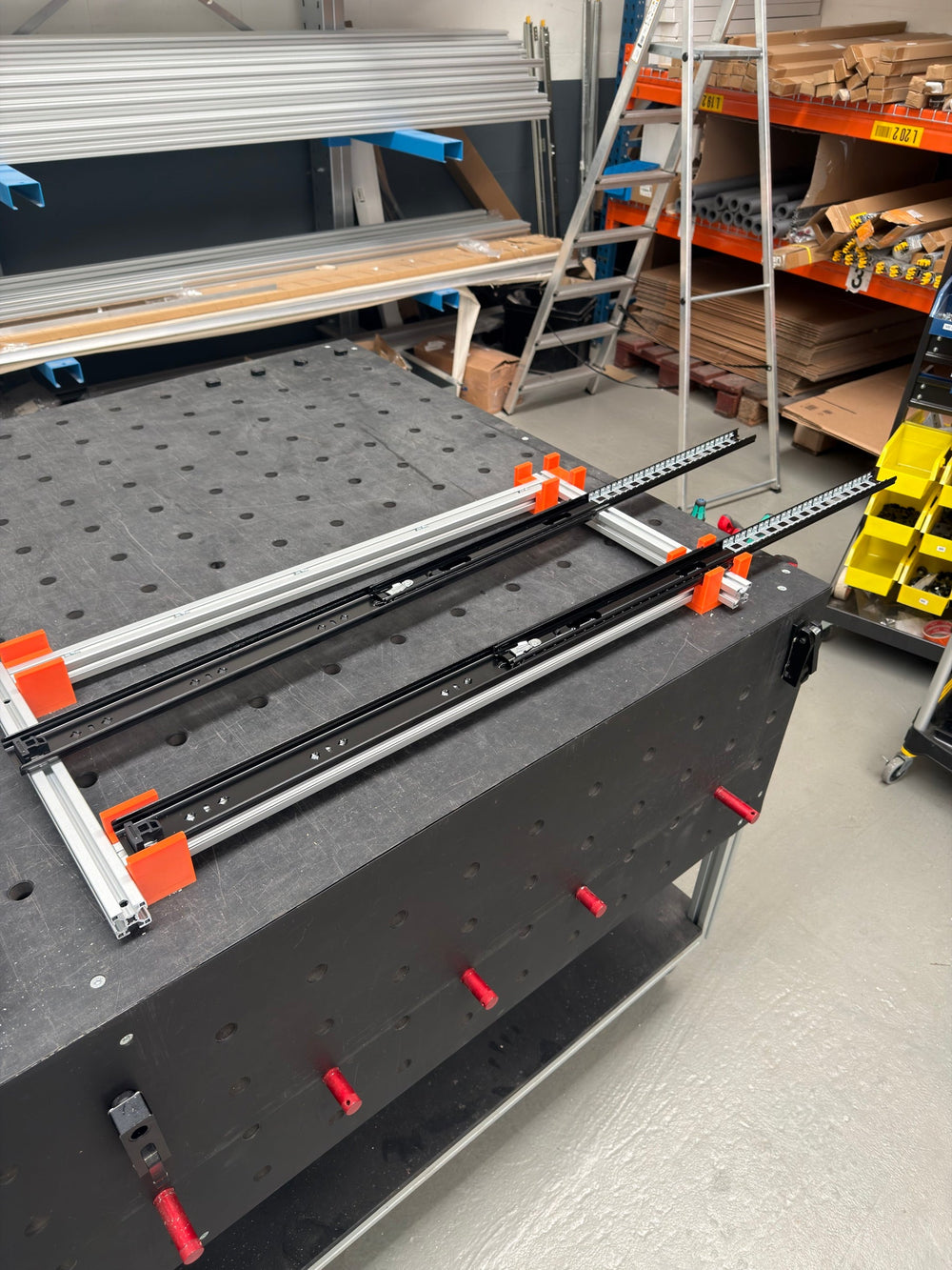 Aluminium frame met uitschuifgeleiders tijdens de opbouw op de werkbank van Kampfinity
