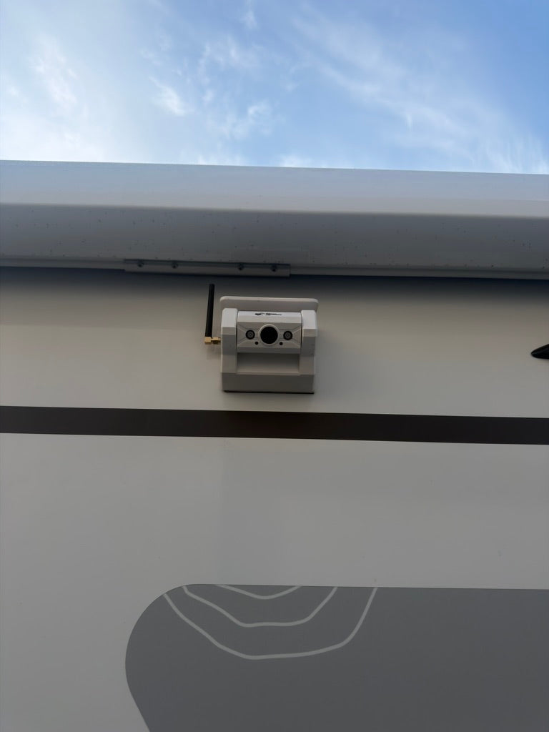 Witte Kampfinity draadloze camera gemonteerd op de buitenwand van een camper