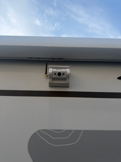 Witte Kampfinity draadloze camera gemonteerd op de buitenwand van een camper